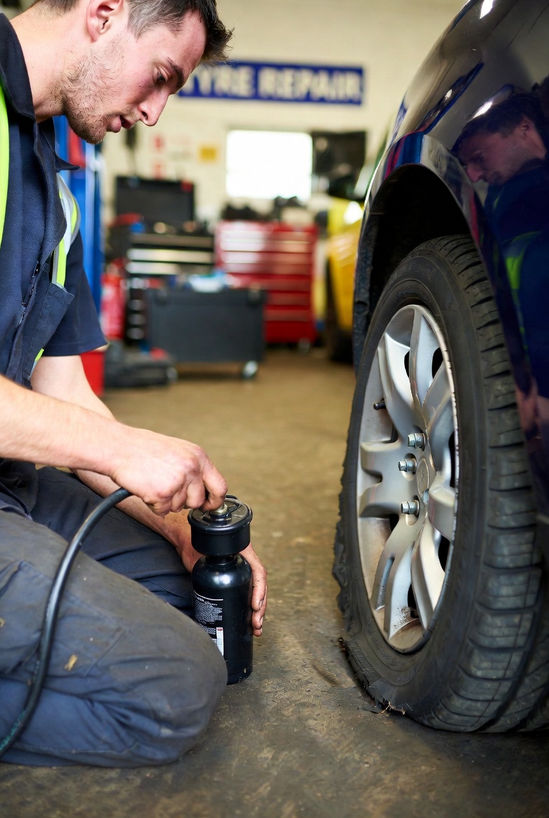 Mechanic performing emergency tyre puncture repair